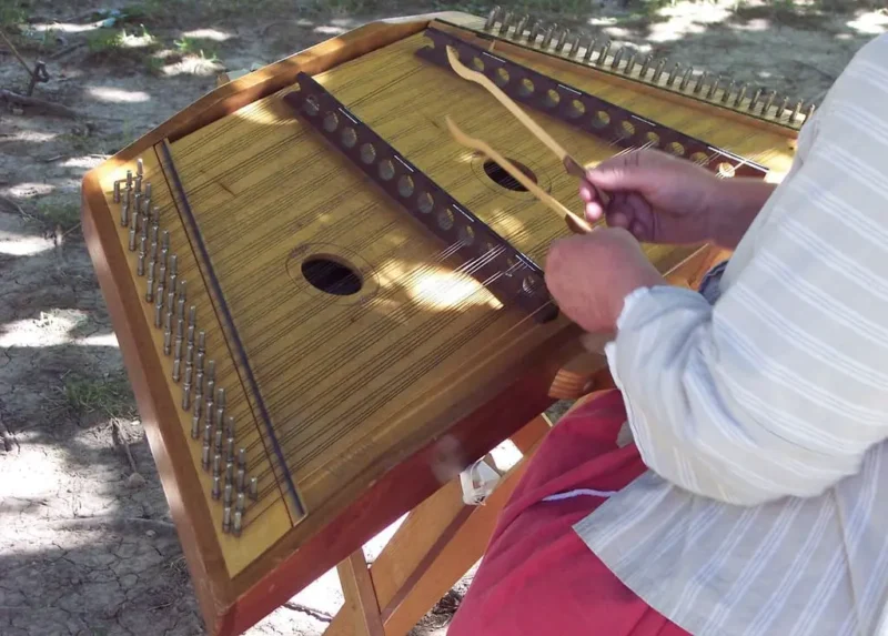 All the Musical Instruments That Start With The Letter D 1 A Hammer Dulcimer, played by a musician. In an open park.